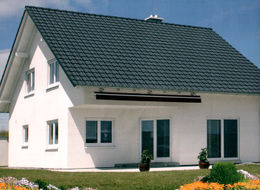 Двухэтажный светлый дом классической формы со стандартным остеклением из бетонных панелей